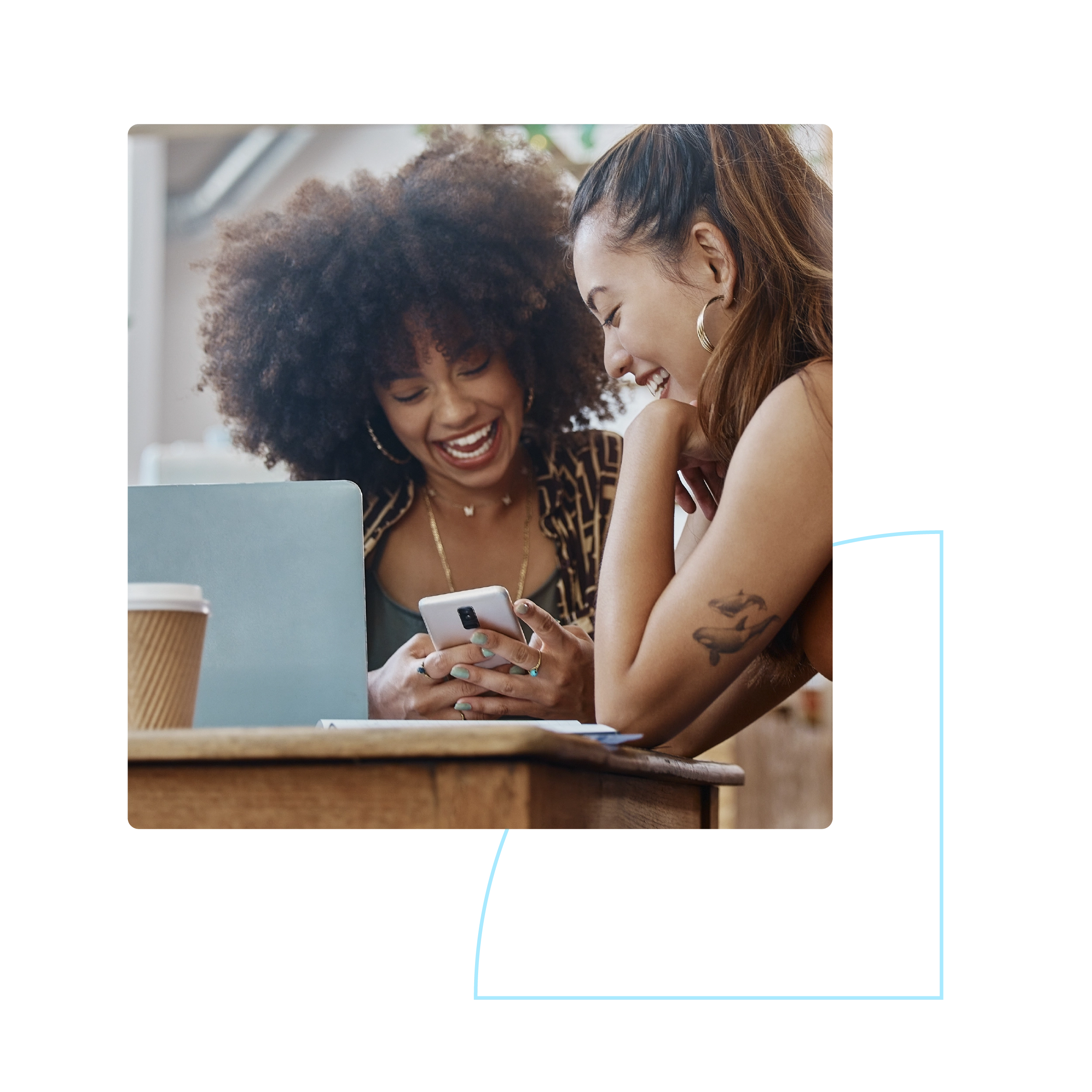 two women smiling at a smartphone